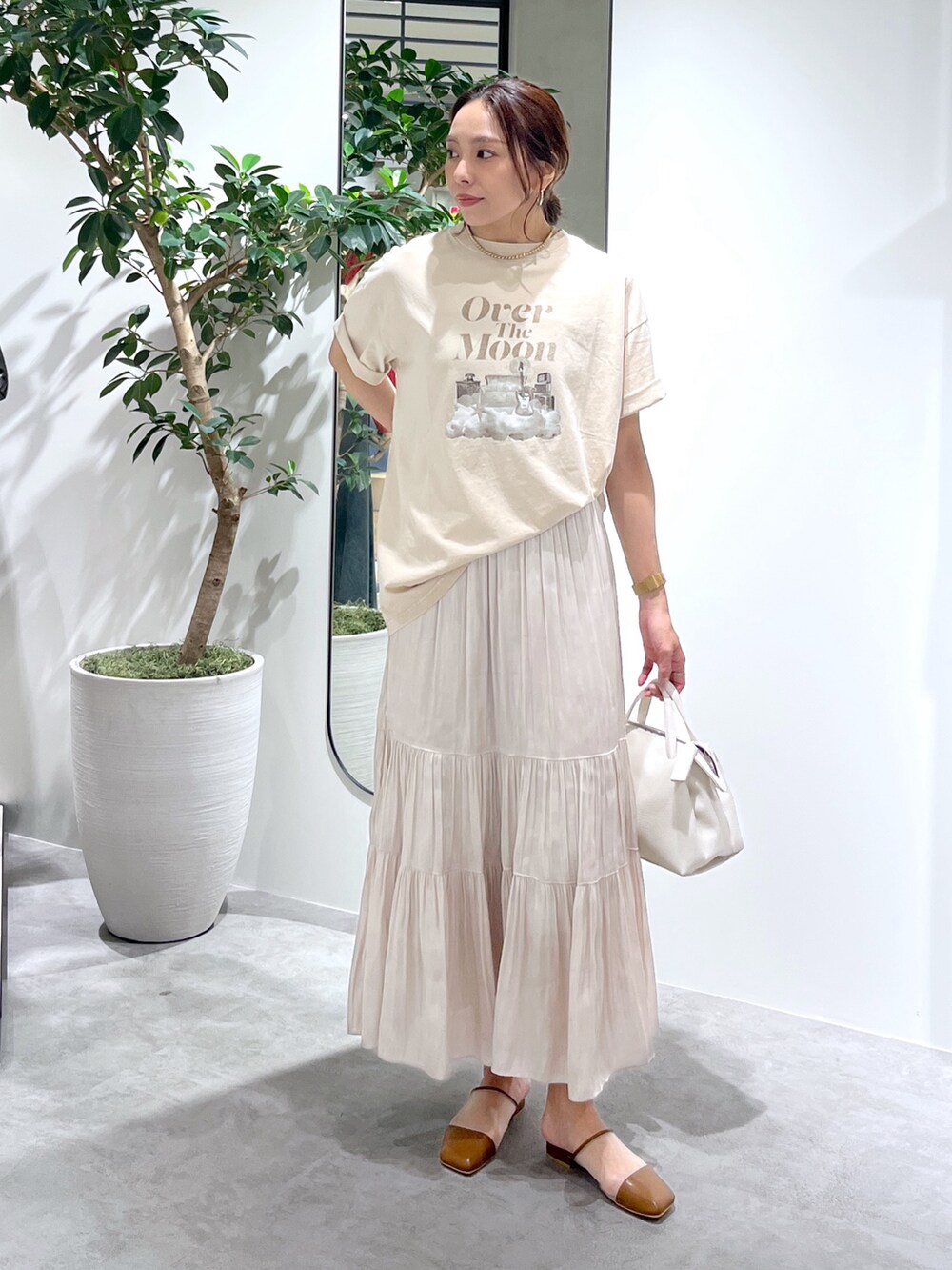 ベージュ系のTシャツ/カットソー、ホワイト系のショルダーバッグ、ホワイト系のスカートを着用したレディースの春コーディネートの8枚目の写真