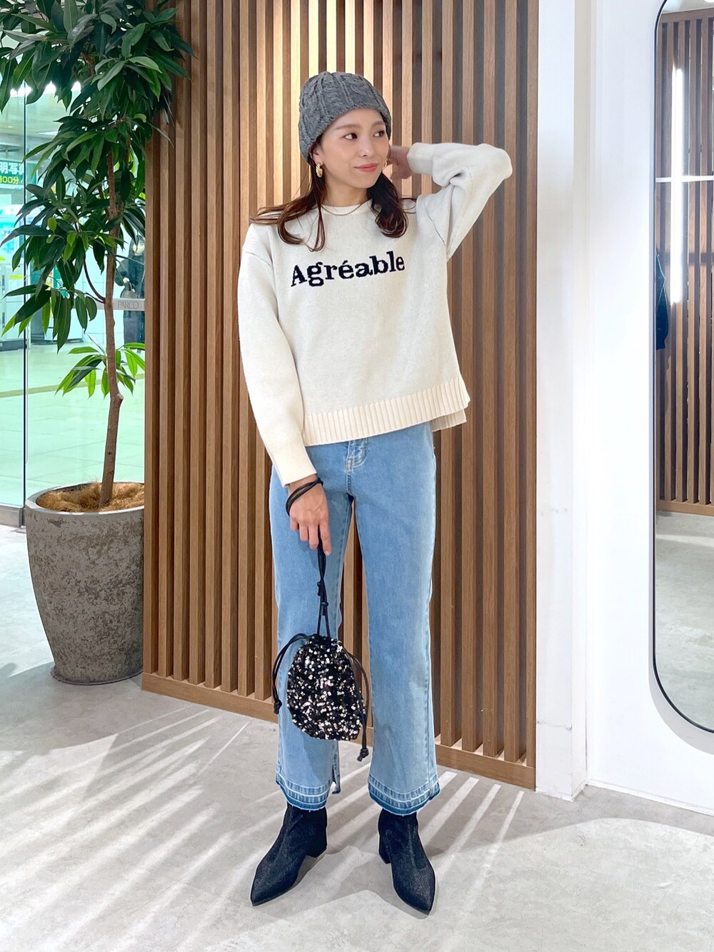 ホワイト系のニット/セーター、ブルー系のデニムパンツ、ブラック系のブーツを着用したレディースの秋コーディネートの5枚目の写真