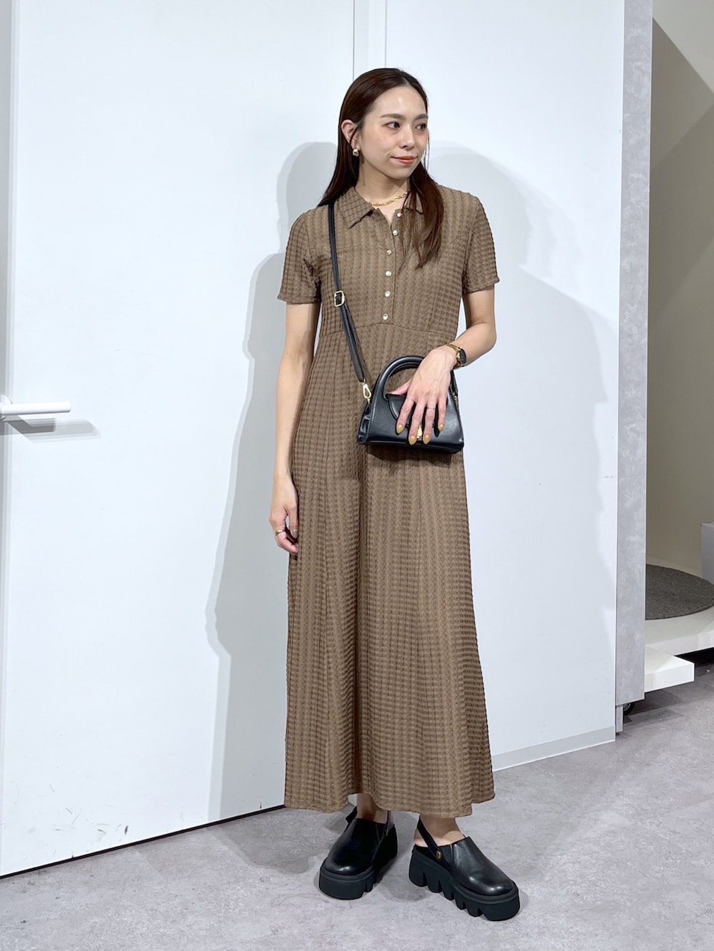 ブラック系のショルダーバッグ、ブラック系のサンダル、ブラウン系のワンピースを着用したレディースの春コーディネートの9枚目の写真