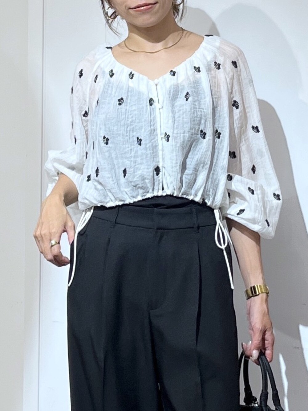 ブラック系のボストンバッグ、ブラック系のスラックス、ブラック系のパンプスを着用したレディースの夏コーディネートの8枚目の写真