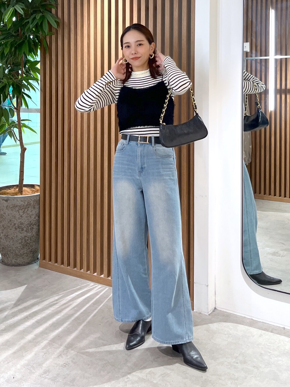 ブラック系のキャミソール、ホワイト系のニット/セーター、ブラック系のトートバッグを着用したレディースの秋コーディネートの2枚目の写真