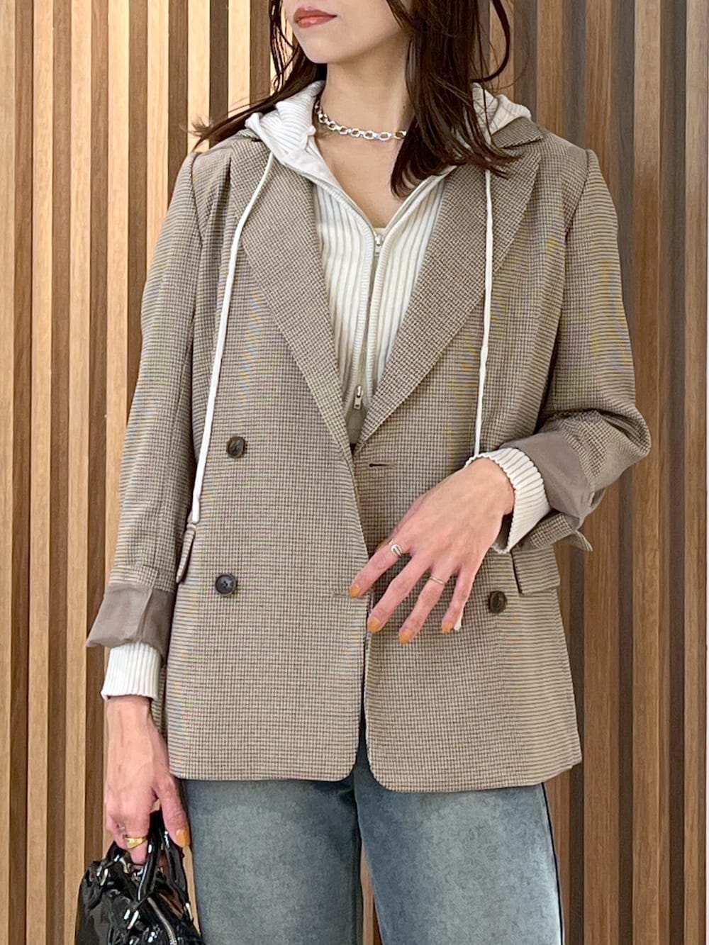 ホワイト系のニット/セーター、ベージュ系のテーラードジャケット、ブルー系のデニムパンツを着用したレディースの冬コーディネートの6枚目の写真