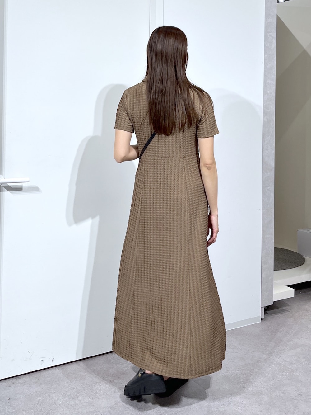 ブラック系のショルダーバッグ、ブラック系のサンダル、ブラウン系のワンピースを着用したレディースの春コーディネートの6枚目の写真