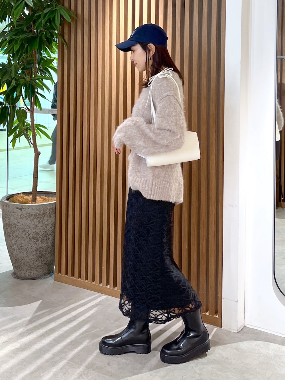 ホワイト系のショルダーバッグ、ベージュ系のニット/セーター、ブラック系のスカートを着用したレディースの冬コーディネートの6枚目の写真