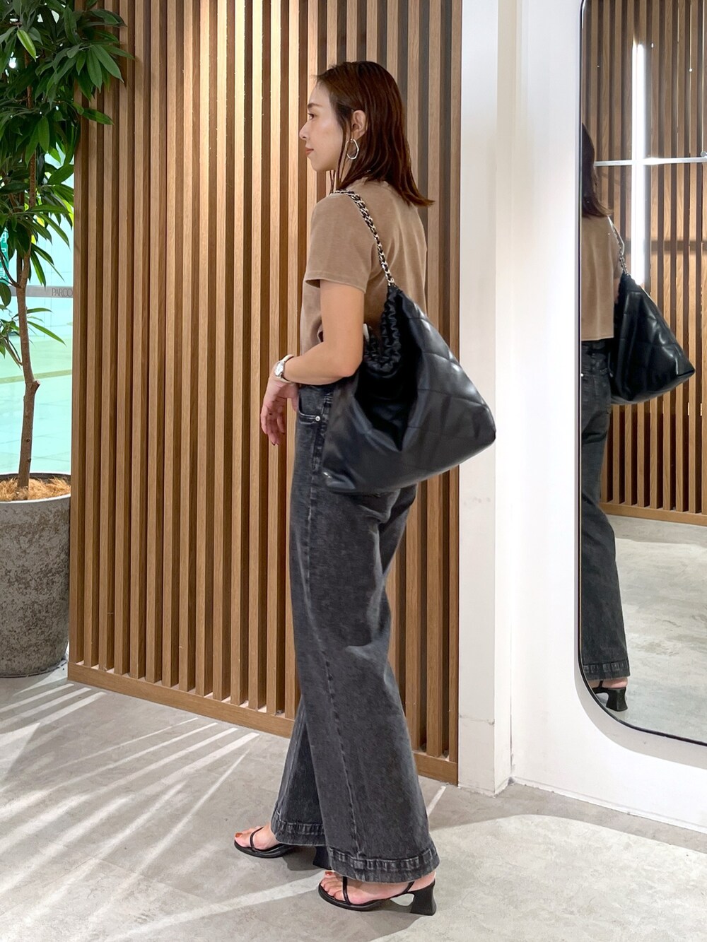 ブラウン系のTシャツ/カットソー、ブラック系のトートバッグ、ブラック系のデニムパンツを着用したレディースの秋コーディネートの6枚目の写真