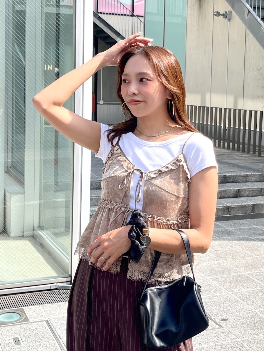 ブラック系のハンドバッグ、ブラック系のパンプス、ホワイト系のTシャツ/カットソーを着用したレディースの夏コーディネートの5枚目の写真
