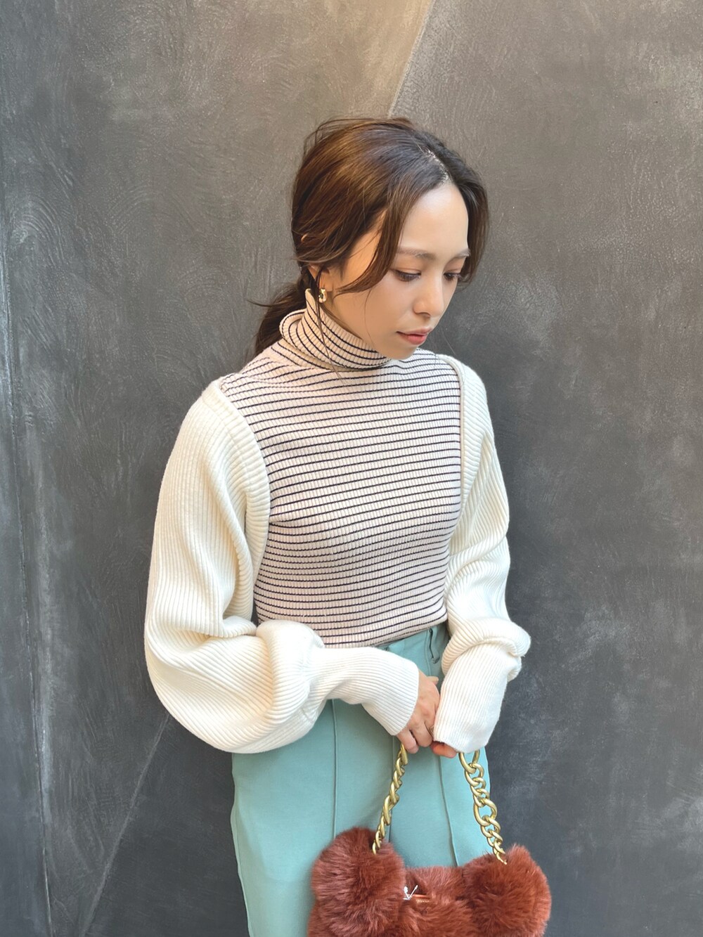 ブラウン系のハンドバッグ、ホワイト系のカーディガン/ボレロ、ホワイト系のニット/セーターを着用したレディースの秋コーディネートの5枚目の写真