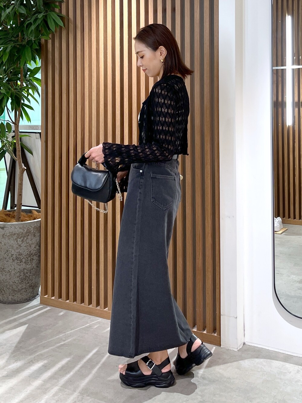 ブラック系のサンダル、ブラック系のショルダーバッグ、ホワイト系のキャミソールを着用したレディースの夏コーディネートの4枚目の写真