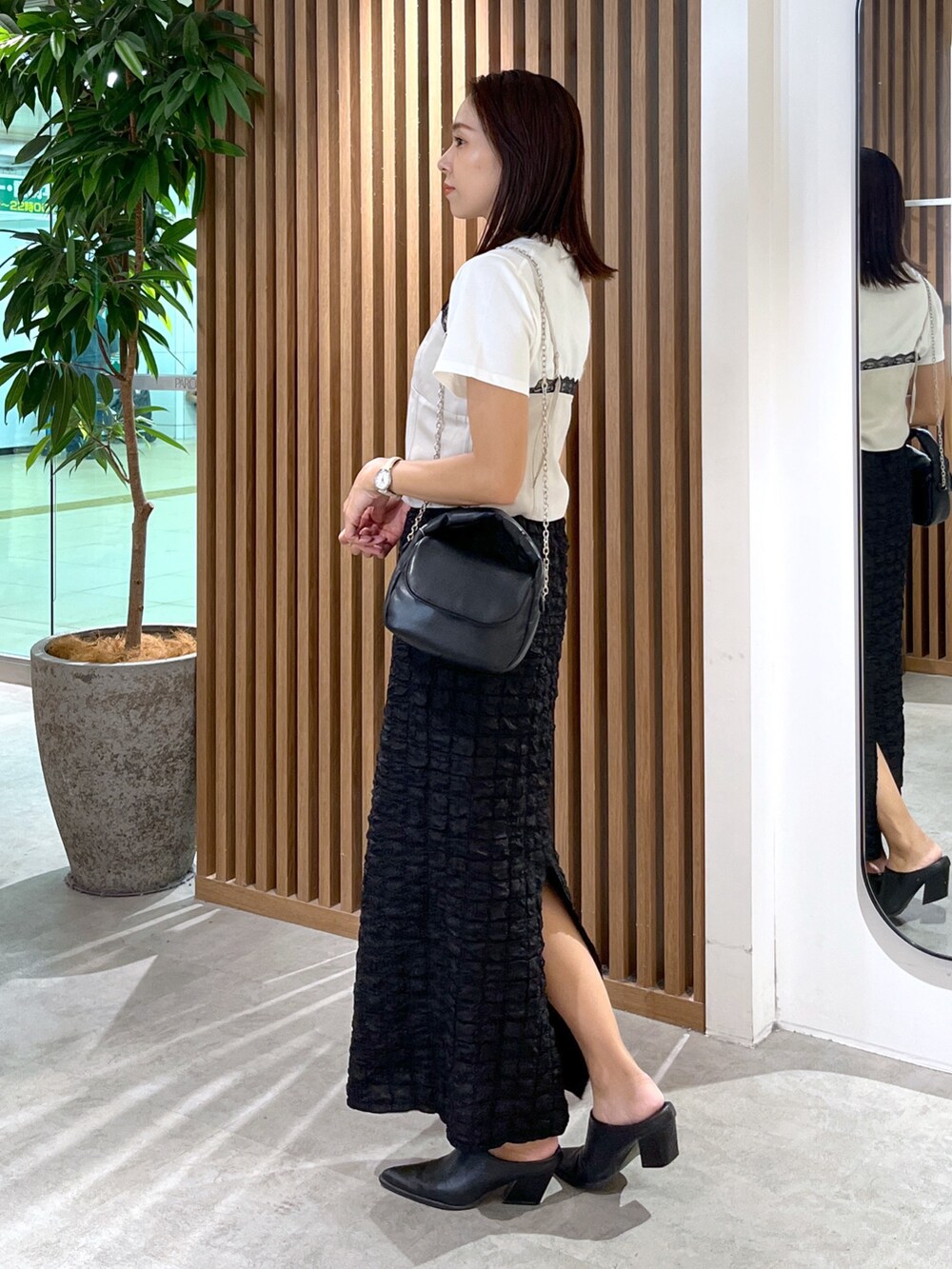 ブラック系のスカート、ホワイト系のTシャツ/カットソー、グレー系のキャミソールを着用したレディースの秋コーディネートの4枚目の写真