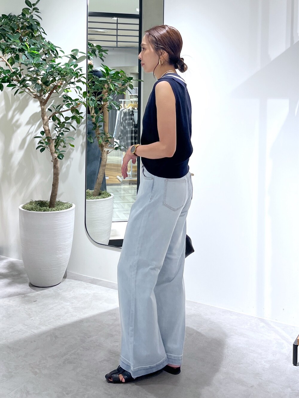 ブルー系のニット/セーター、ブルー系のデニムパンツ、ブラック系のショルダーバッグを着用したレディースの夏コーディネートの3枚目の写真