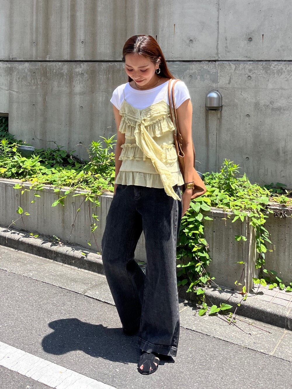 イエロー系のシャツ/ブラウス、ブラック系のデニムパンツ、ブラック系のサンダルを着用したレディースの夏コーディネートの2枚目の写真