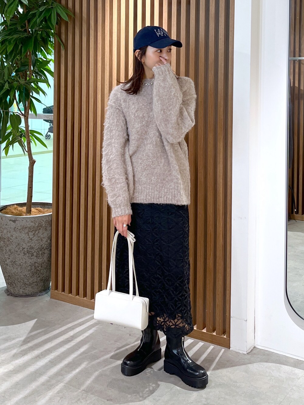 ホワイト系のショルダーバッグ、ベージュ系のニット/セーター、ブラック系のスカートを着用したレディースの冬コーディネートの5枚目の写真