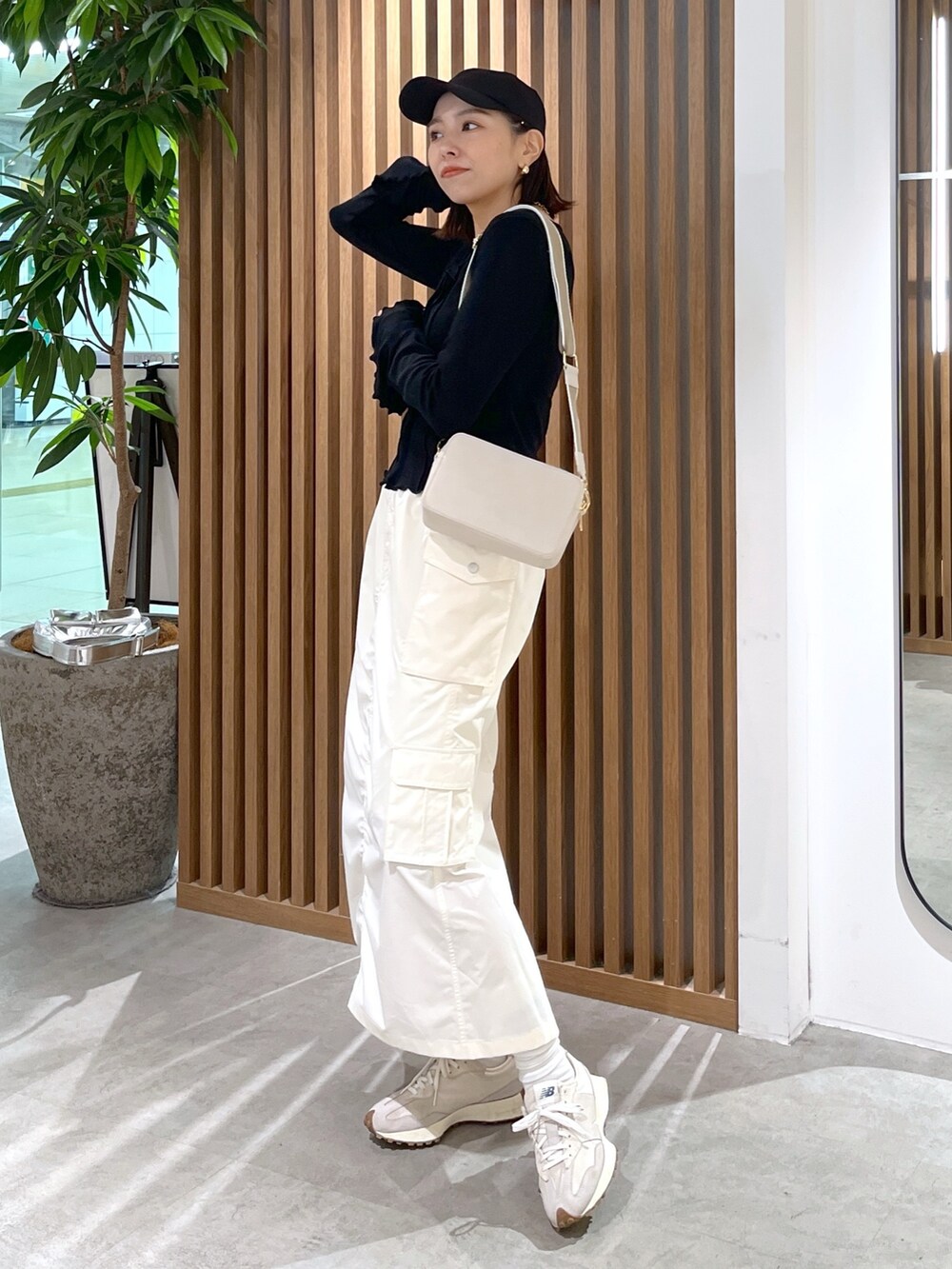 ホワイト系のボディバッグ/ウエストポーチ、ブラック系のトップス、ホワイト系のスカートを着用したレディースの春コーディネートの5枚目の写真