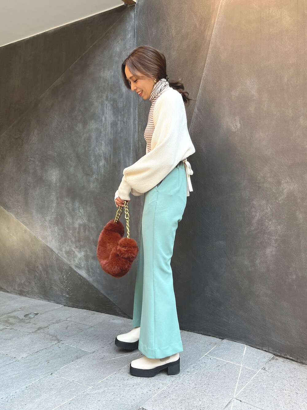 ブラウン系のハンドバッグ、ホワイト系のカーディガン/ボレロ、ホワイト系のニット/セーターを着用したレディースの秋コーディネートの2枚目の写真