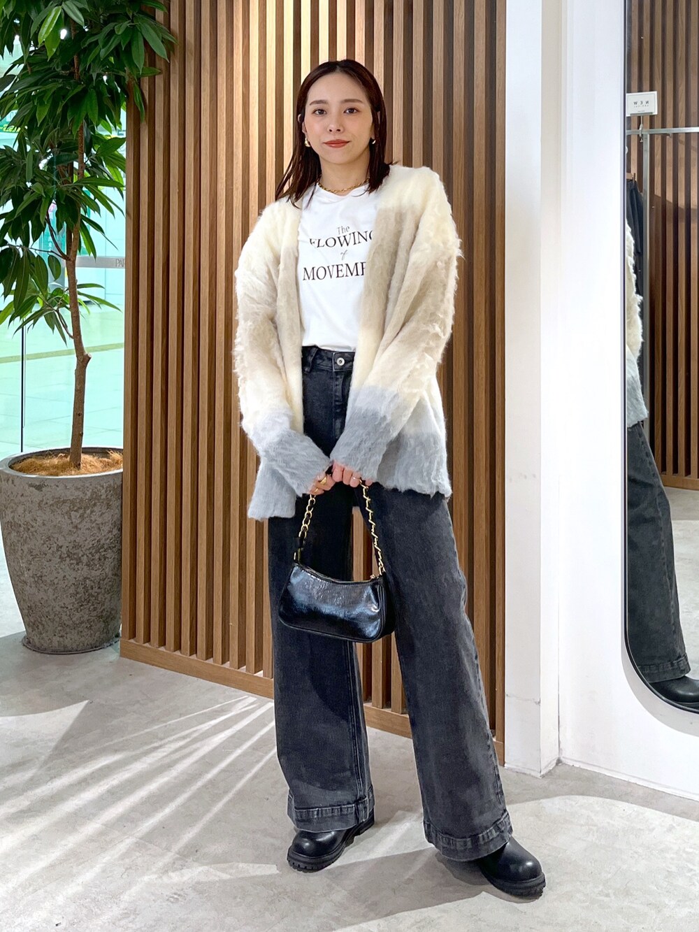 ベージュ系のカーディガン/ボレロ、ホワイト系のTシャツ/カットソー、ブラック系のトートバッグを着用したレディースの秋コーディネートの3枚目の写真
