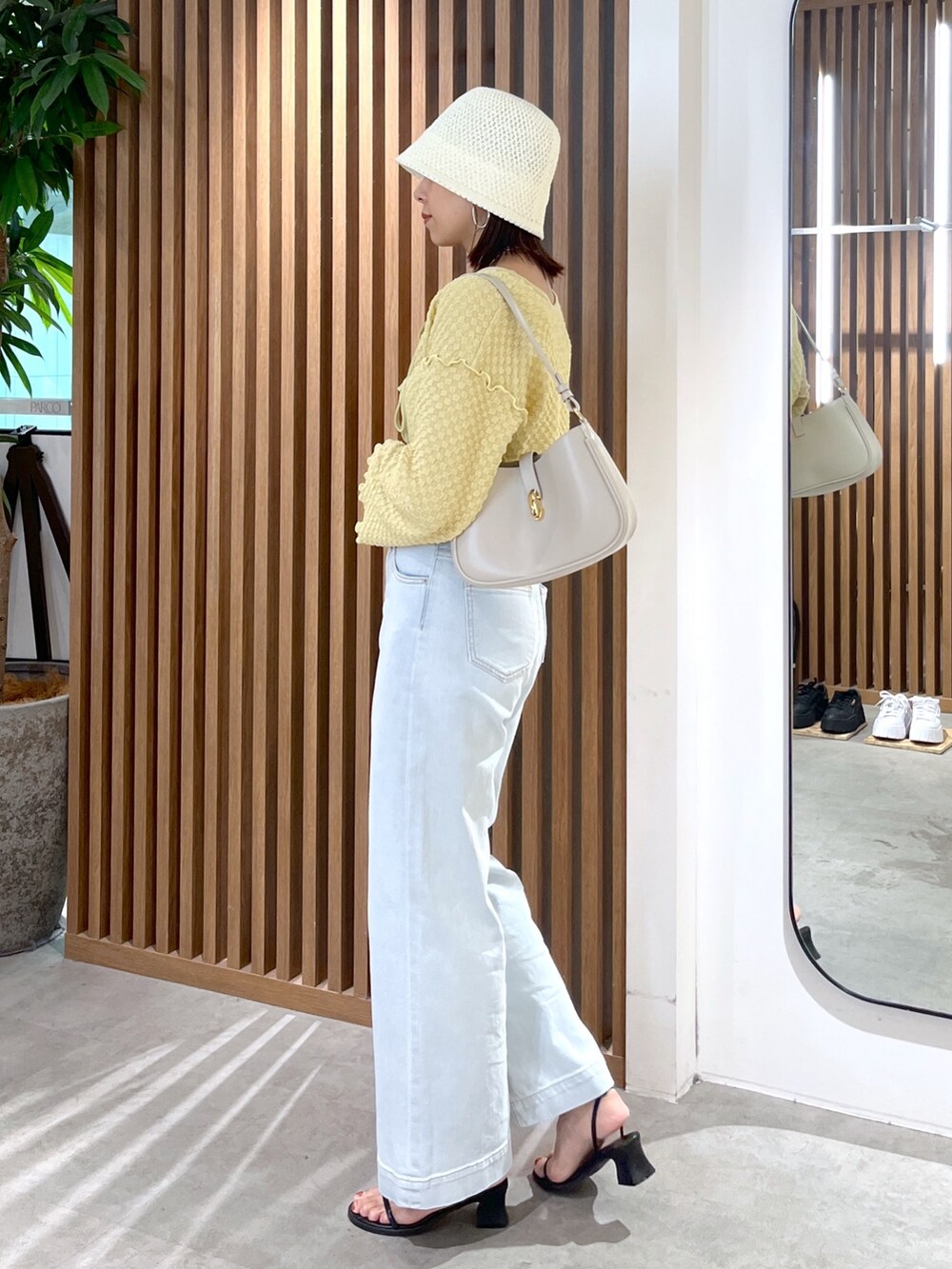 イエロー系のカーディガン/ボレロ、ブルー系のデニムパンツ、グレー系のショルダーバッグを着用したレディースの夏コーディネートの4枚目の写真