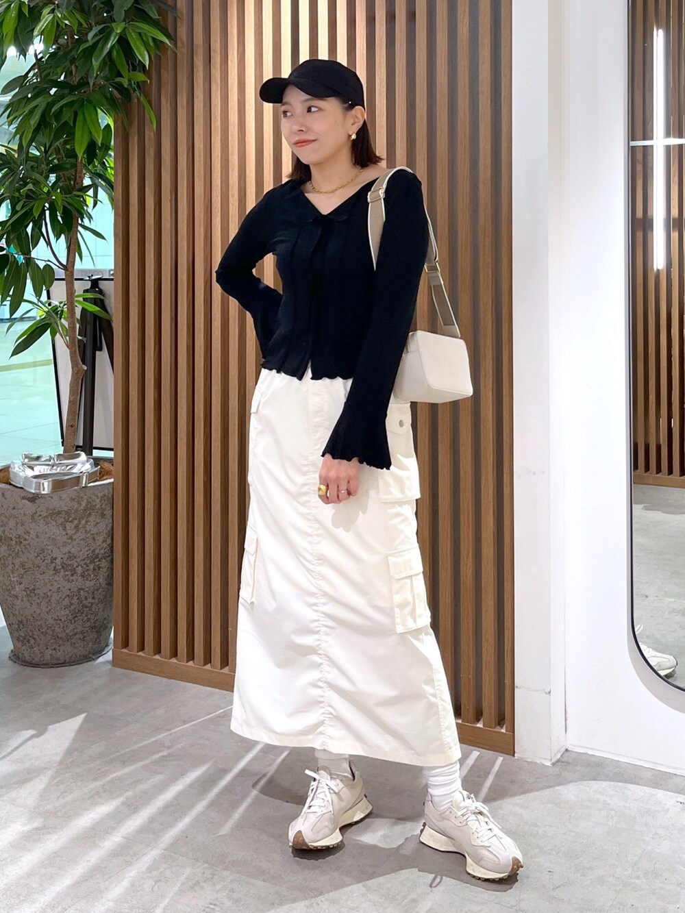 ホワイト系のボディバッグ/ウエストポーチ、ブラック系のトップス、ホワイト系のスカートを着用したレディースの春コーディネートの8枚目の写真