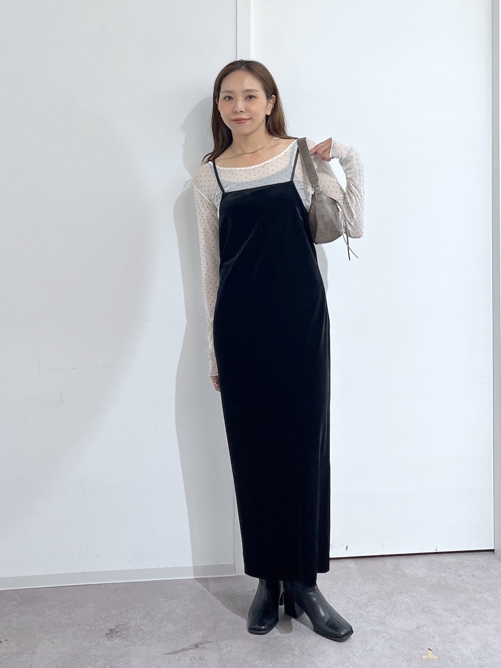 ブラウン系のショルダーバッグ、ブラック系のワンピース、ホワイト系のTシャツ/カットソーを着用したレディースの夏コーディネートの2枚目の写真
