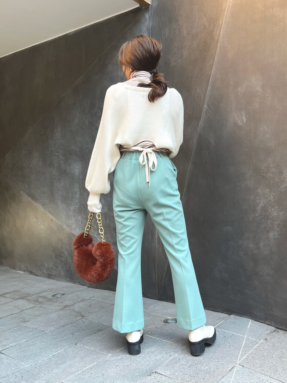 ブラウン系のハンドバッグ、ホワイト系のカーディガン/ボレロ、ホワイト系のニット/セーターを着用したレディースの秋コーディネートの4枚目の写真