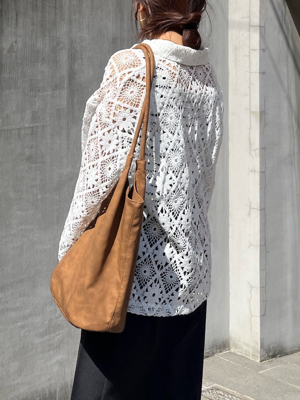 ブラック系のスラックス、ブラウン系のトートバッグ、ホワイト系のブルゾンを着用したレディースの春コーディネートの7枚目の写真