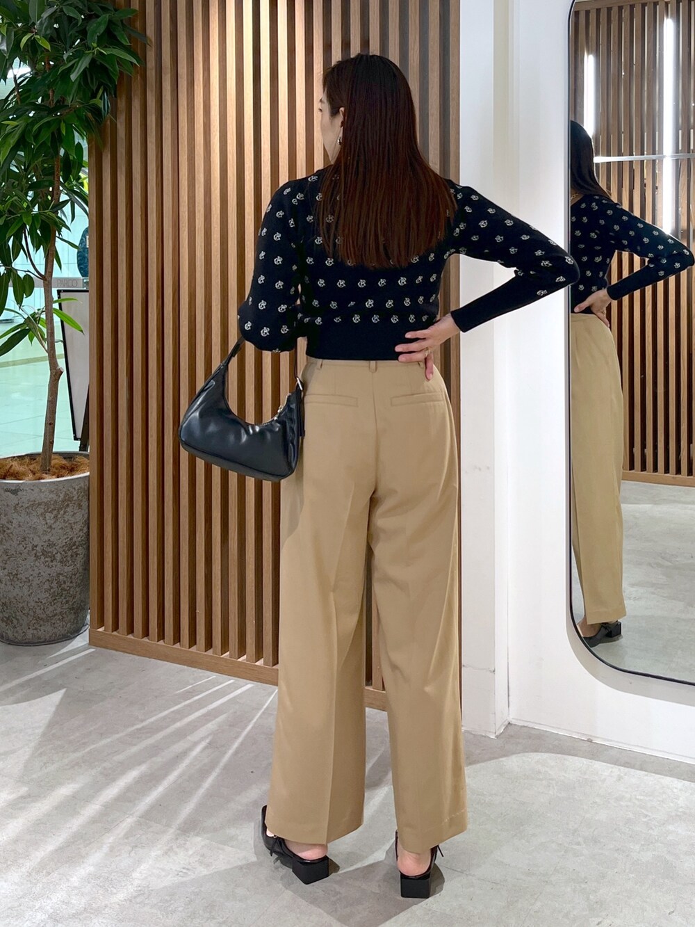 ブラック系のパンプス、ブラック系のショルダーバッグ、ブラック系のニット/セーターを着用したレディースの冬コーディネートの7枚目の写真