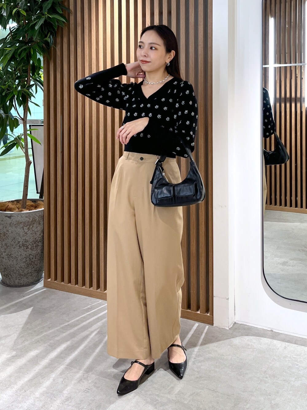 ブラック系のパンプス、ブラック系のショルダーバッグ、ブラック系のニット/セーターを着用したレディースの冬コーディネートの9枚目の写真