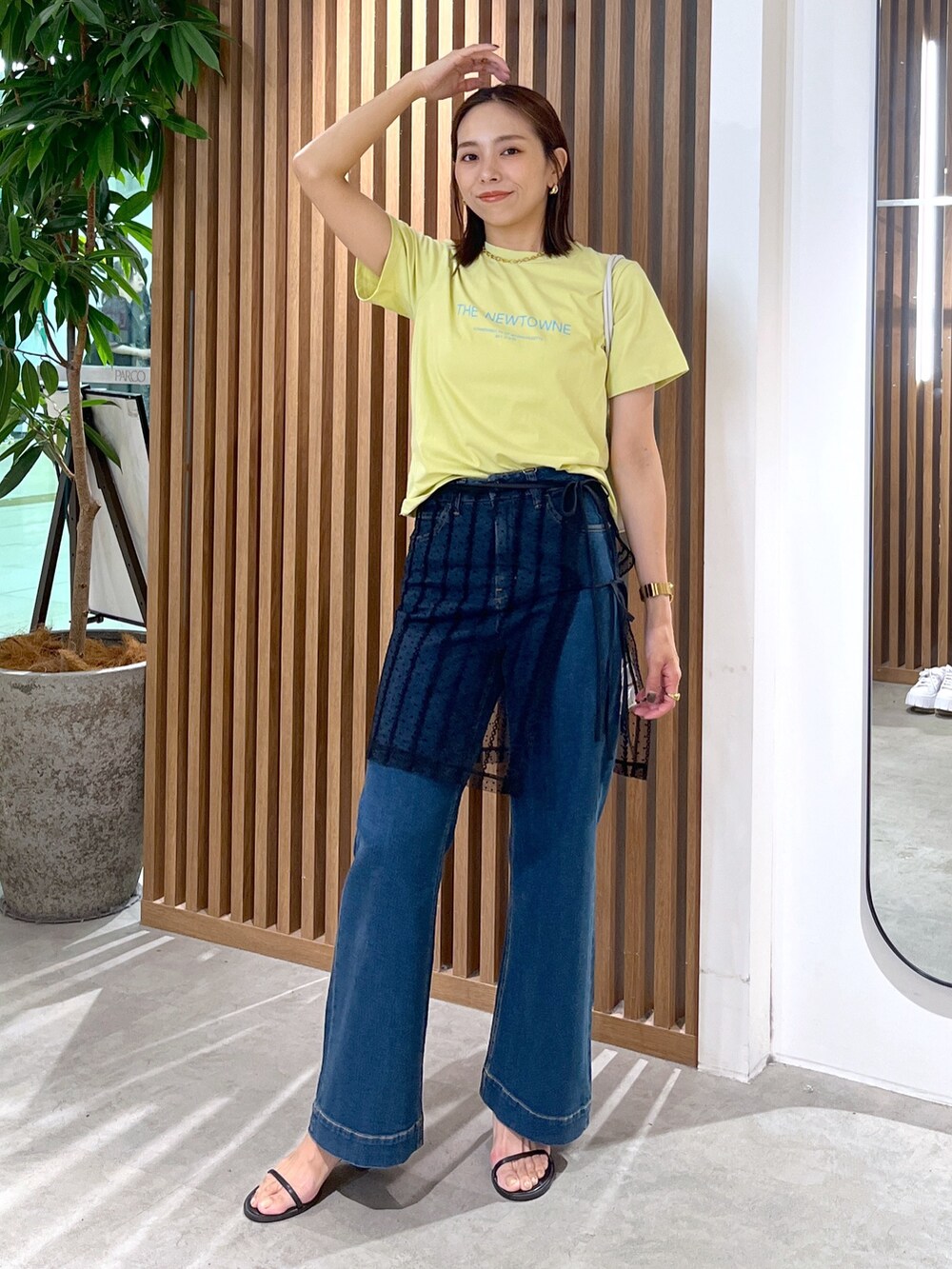 イエロー系のTシャツ/カットソー、ホワイト系のショルダーバッグ、ブラック系のスカートを着用したレディースの夏コーディネートの8枚目の写真