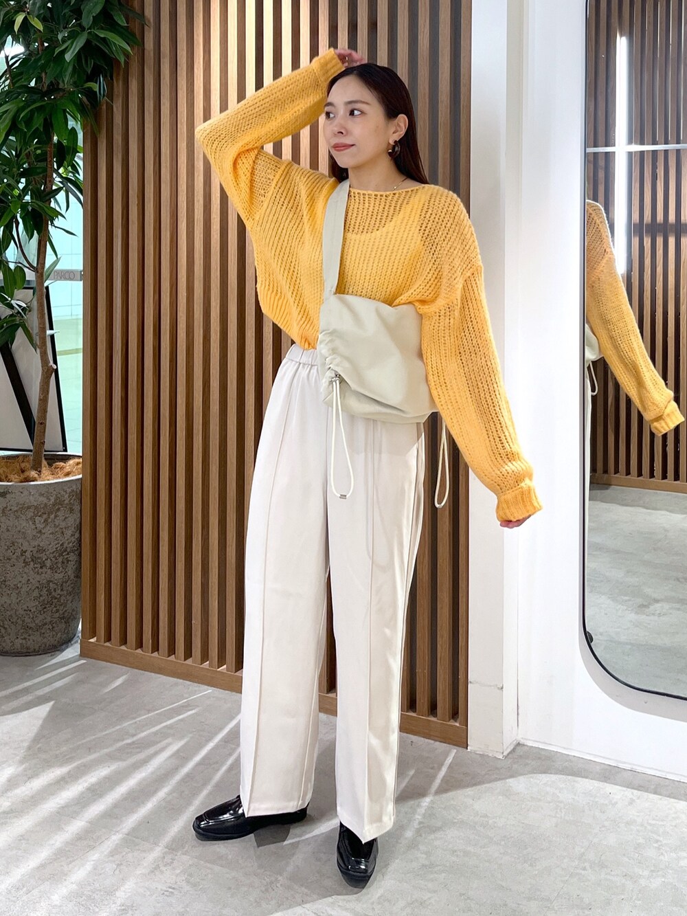 ホワイト系のショルダーバッグ、オレンジ系のニット/セーター、ホワイト系のその他パンツを着用したレディースの冬コーディネートの3枚目の写真