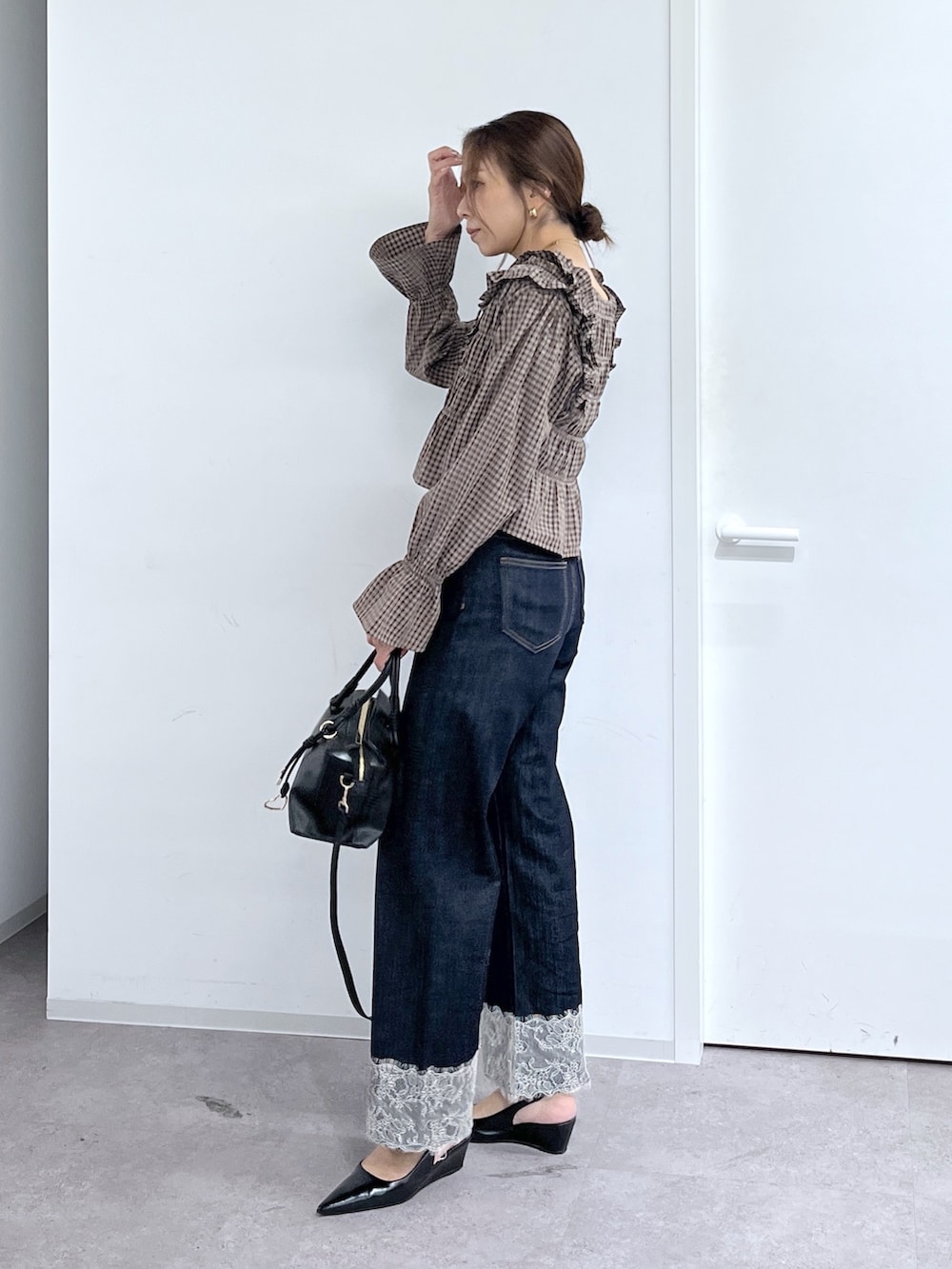 ブルー系のデニムパンツ、ブラック系のハンドバッグ、ブラウン系のシャツ/ブラウスを着用したレディースの秋コーディネートの3枚目の写真