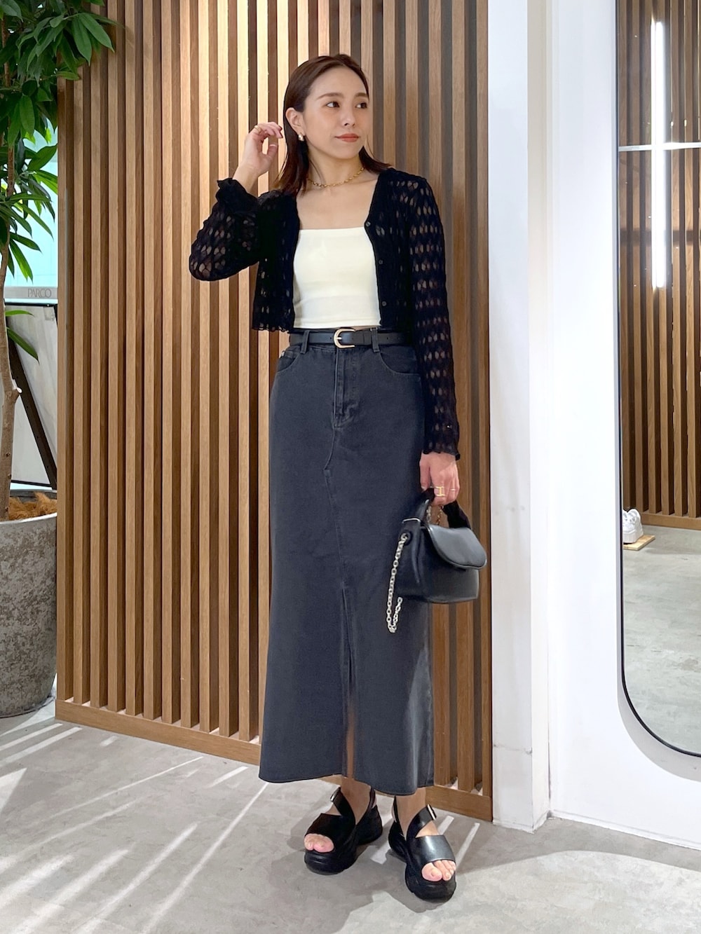 ブラック系のサンダル、ブラック系のショルダーバッグ、ホワイト系のキャミソールを着用したレディースの夏コーディネートの9枚目の写真