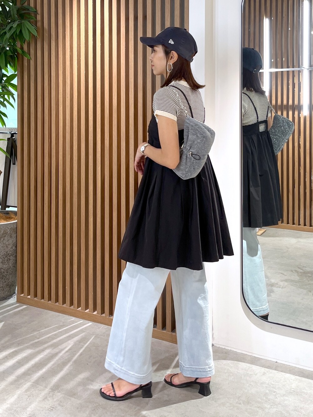 ブラック系のサンダル、ブルー系のデニムパンツ、ブラック系のワンピースを着用したレディースの夏コーディネートの6枚目の写真