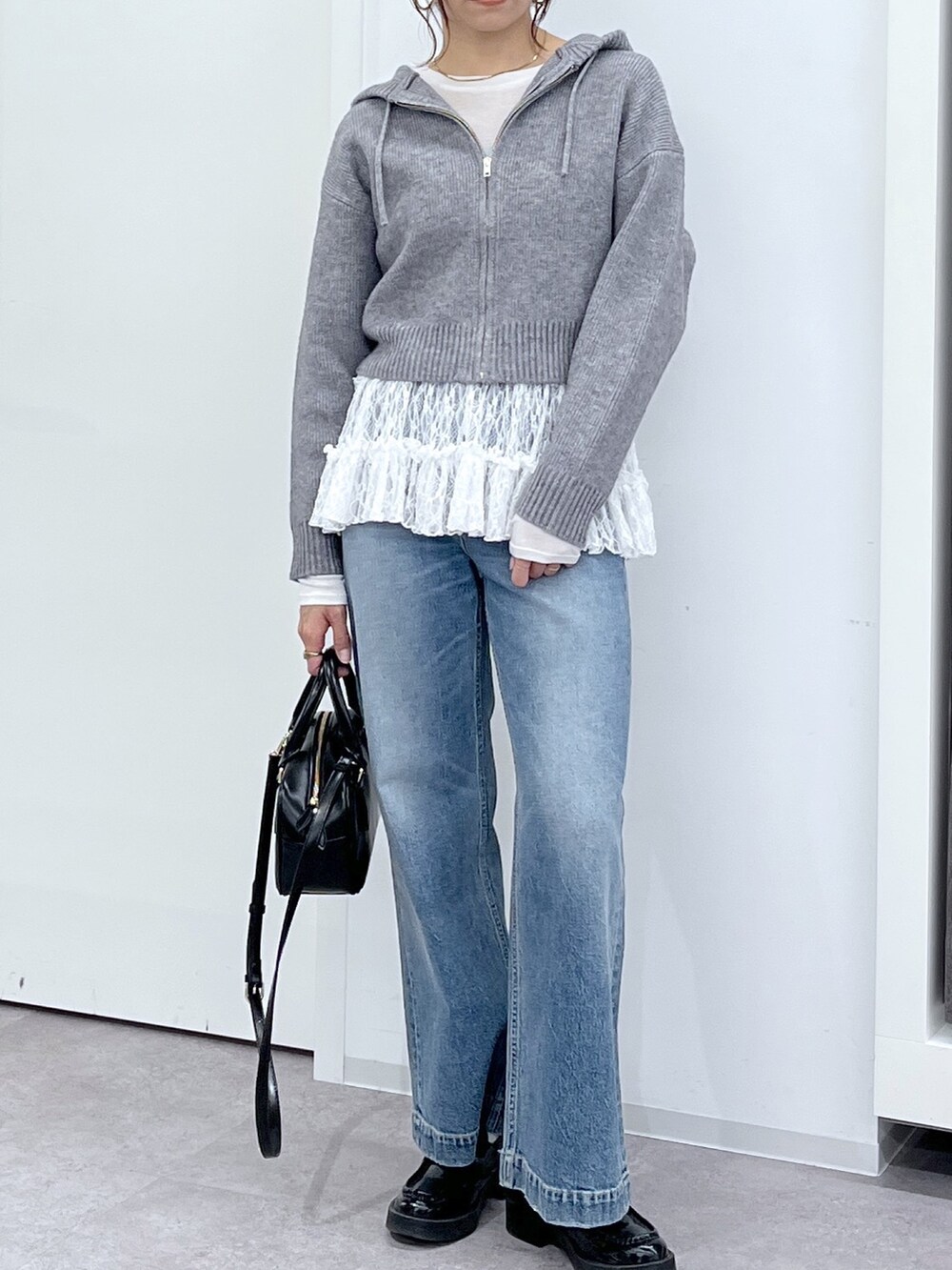 ブラック系のショルダーバッグ、ブルー系のデニムパンツ、ホワイト系のTシャツ/カットソーを着用したレディースの冬コーディネートの10枚目の写真