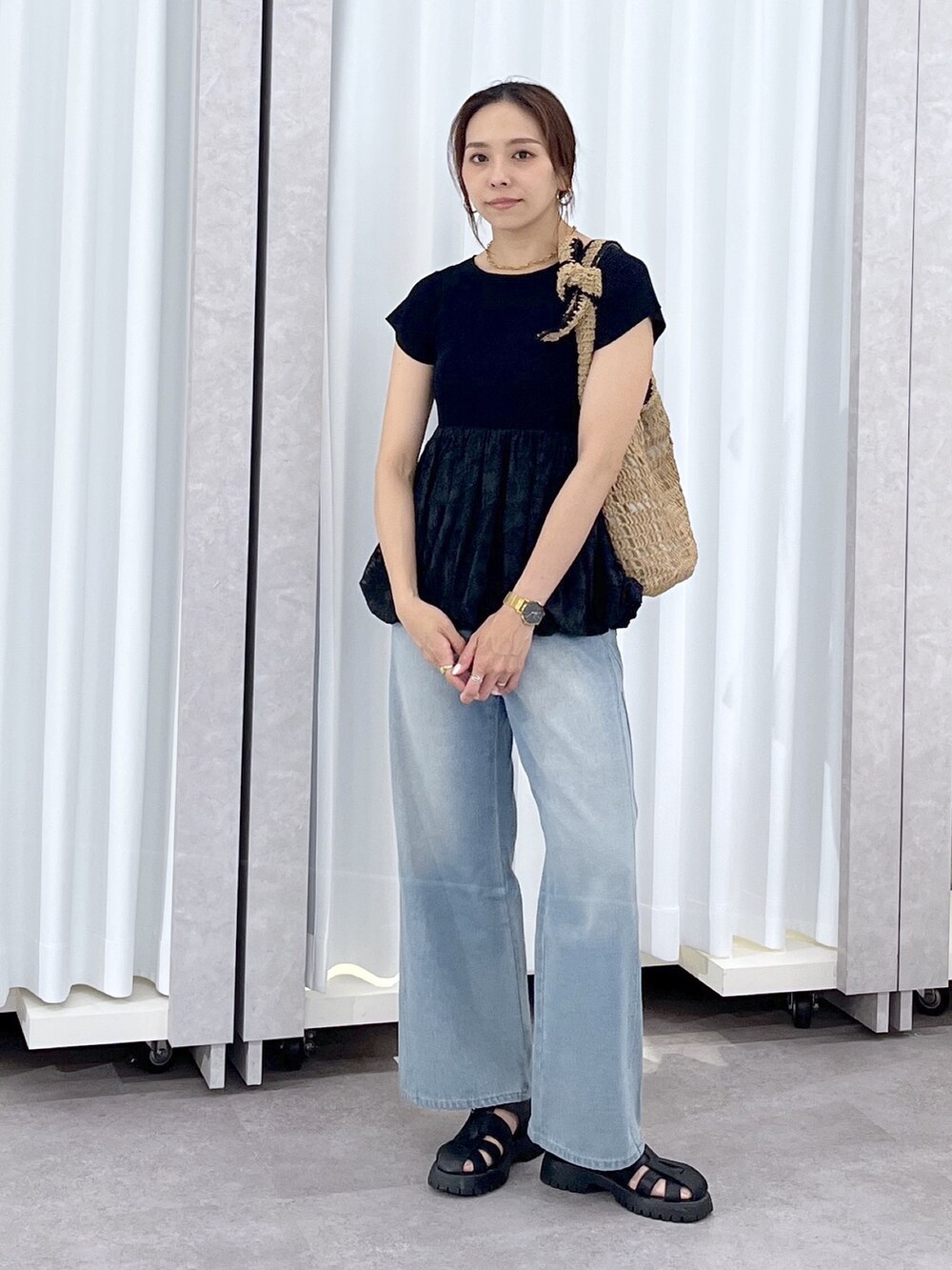 ブルー系のデニムパンツ、ブラック系のニット/セーターを着用したレディースの春コーディネートの2枚目の写真