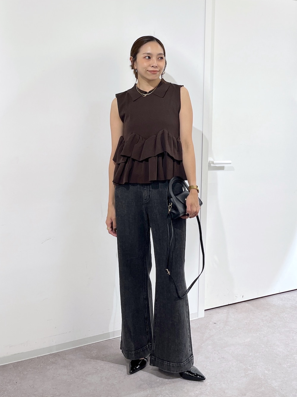 ブラック系のショルダーバッグ、ブラウン系のニット/セーター、ブラック系のデニムパンツを着用したレディースの夏コーディネートの7枚目の写真