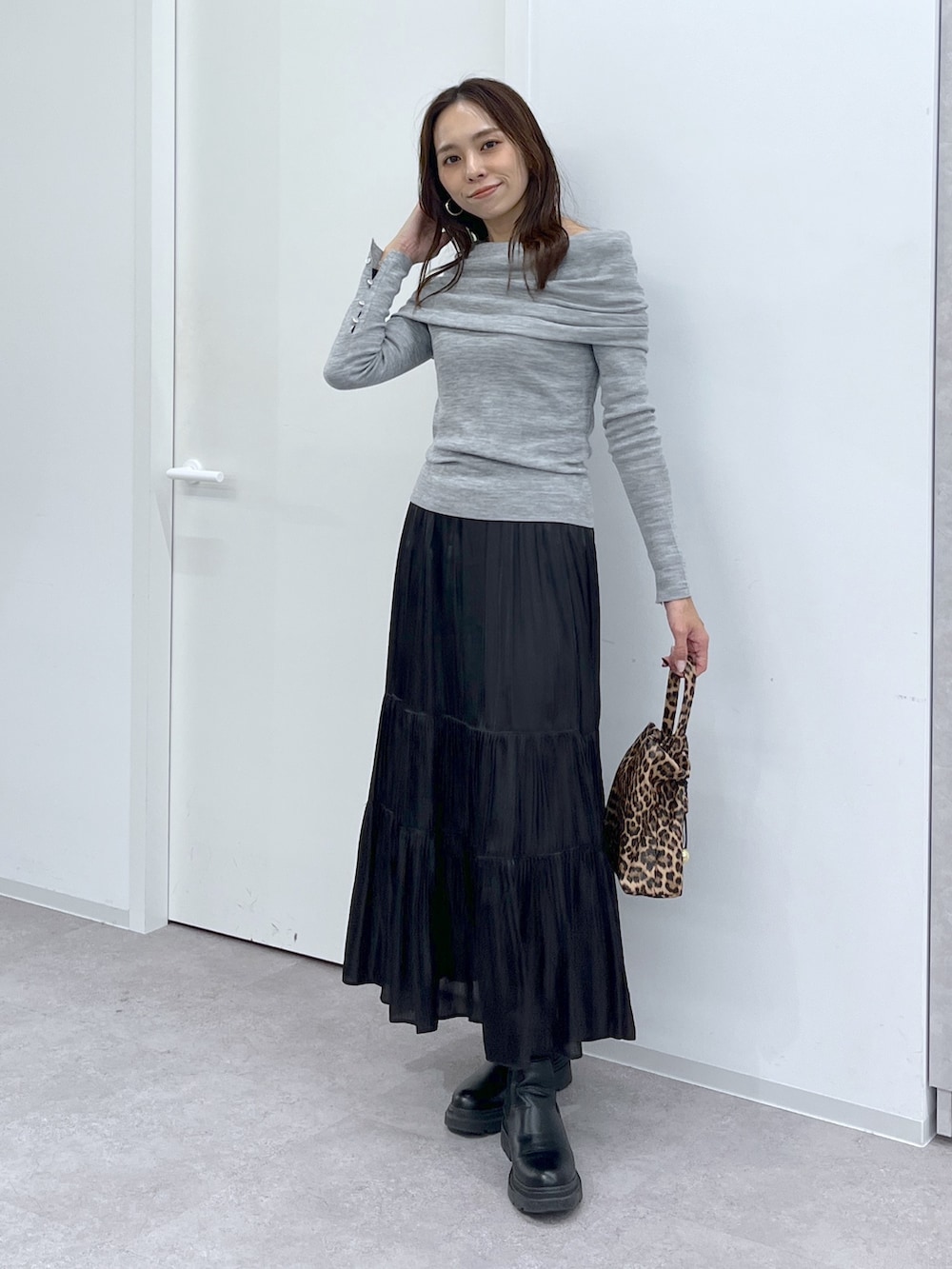 ブラウン系のショルダーバッグ、ブラック系のスカート、グレー系のニット/セーターを着用したレディースの冬コーディネートの4枚目の写真