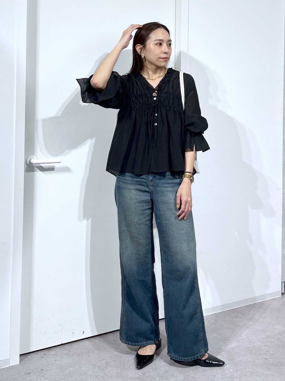 ブラック系のシャツ/ブラウス、ブルー系のデニムパンツを着用したレディースの春コーディネートの8枚目の写真