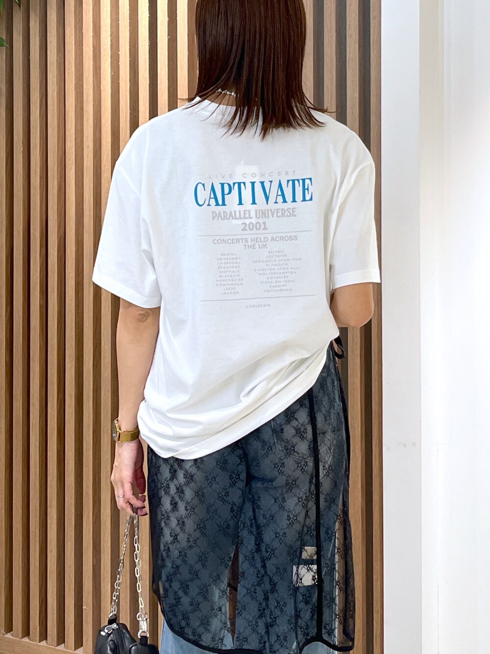 ホワイト系のTシャツ/カットソー、ブラック系のハンドバッグ、ブラック系のスカートを着用したレディースの秋コーディネートの6枚目の写真
