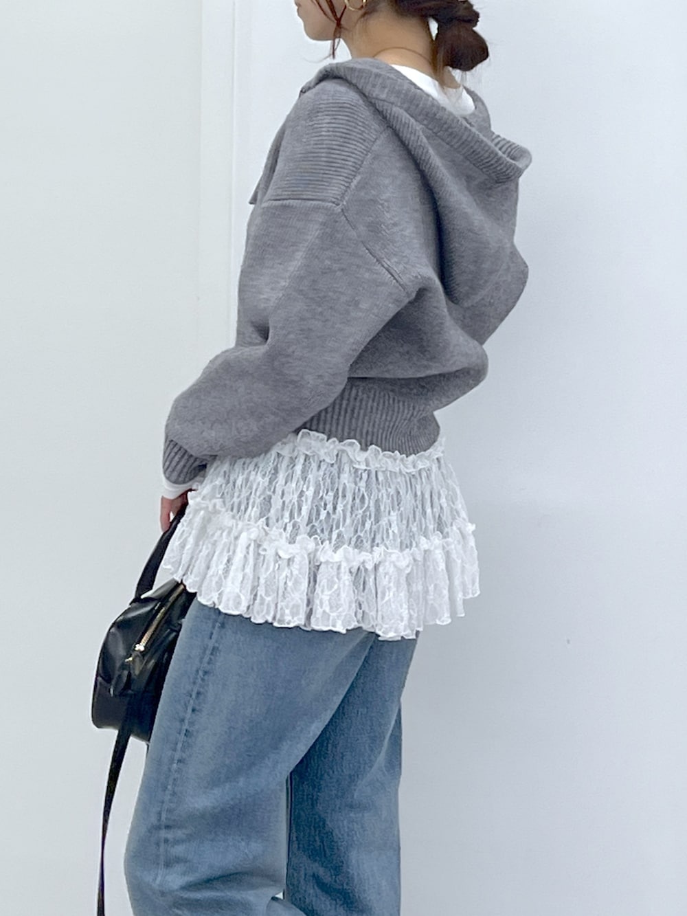 ブラック系のショルダーバッグ、ブルー系のデニムパンツ、ホワイト系のTシャツ/カットソーを着用したレディースの冬コーディネートの9枚目の写真