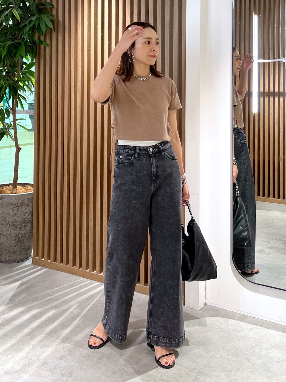 ブラウン系のTシャツ/カットソー、ブラック系のトートバッグ、ブラック系のデニムパンツを着用したレディースの秋コーディネートの9枚目の写真