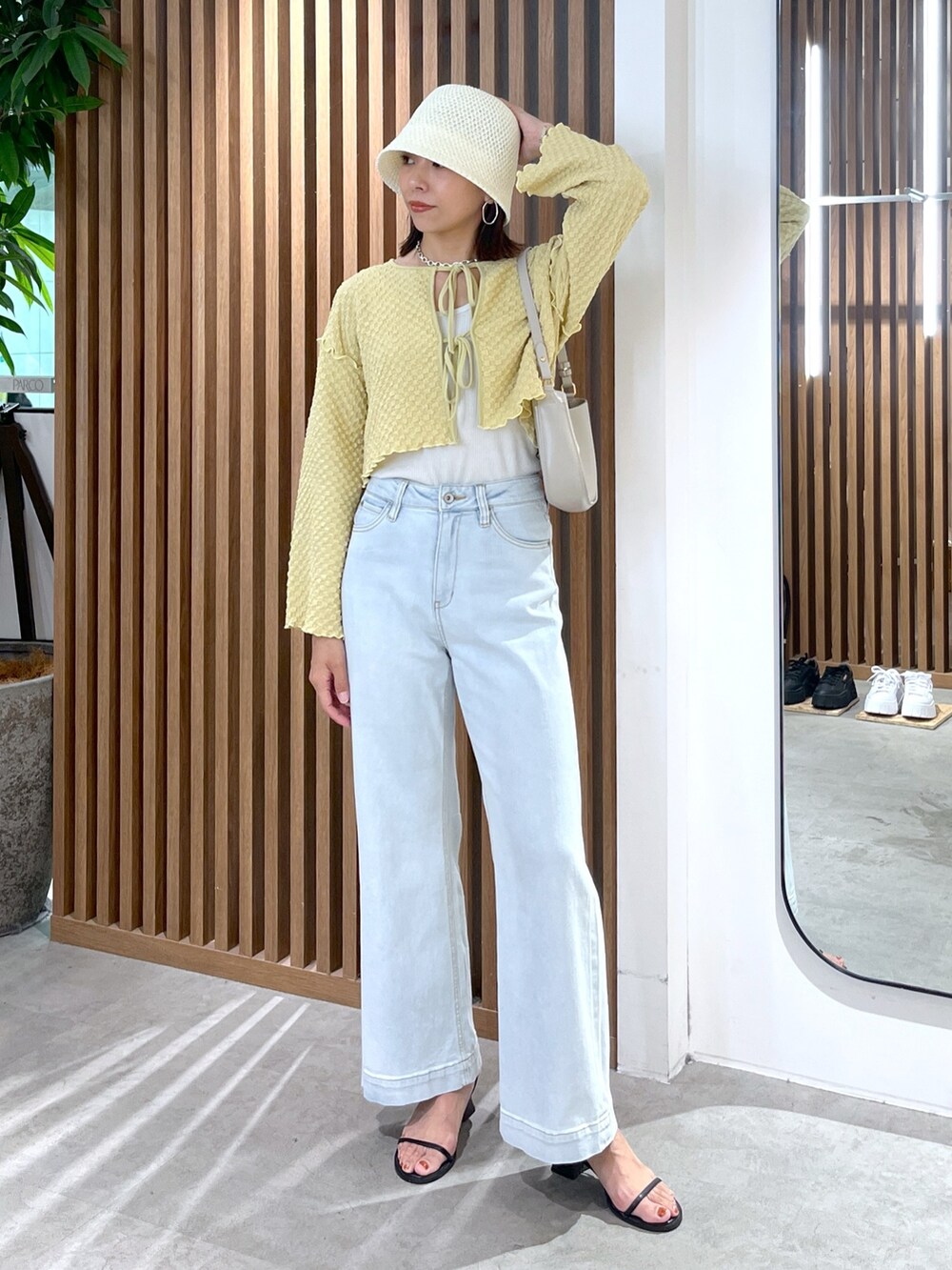 イエロー系のカーディガン/ボレロ、ブルー系のデニムパンツ、グレー系のショルダーバッグを着用したレディースの夏コーディネートの7枚目の写真