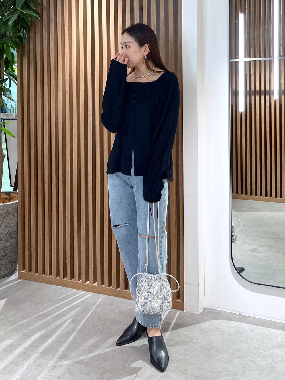 ブラック系のシャツ/ブラウス、ブルー系のデニムパンツ、シルバー系のハンドバッグを着用したレディースの冬コーディネートの6枚目の写真