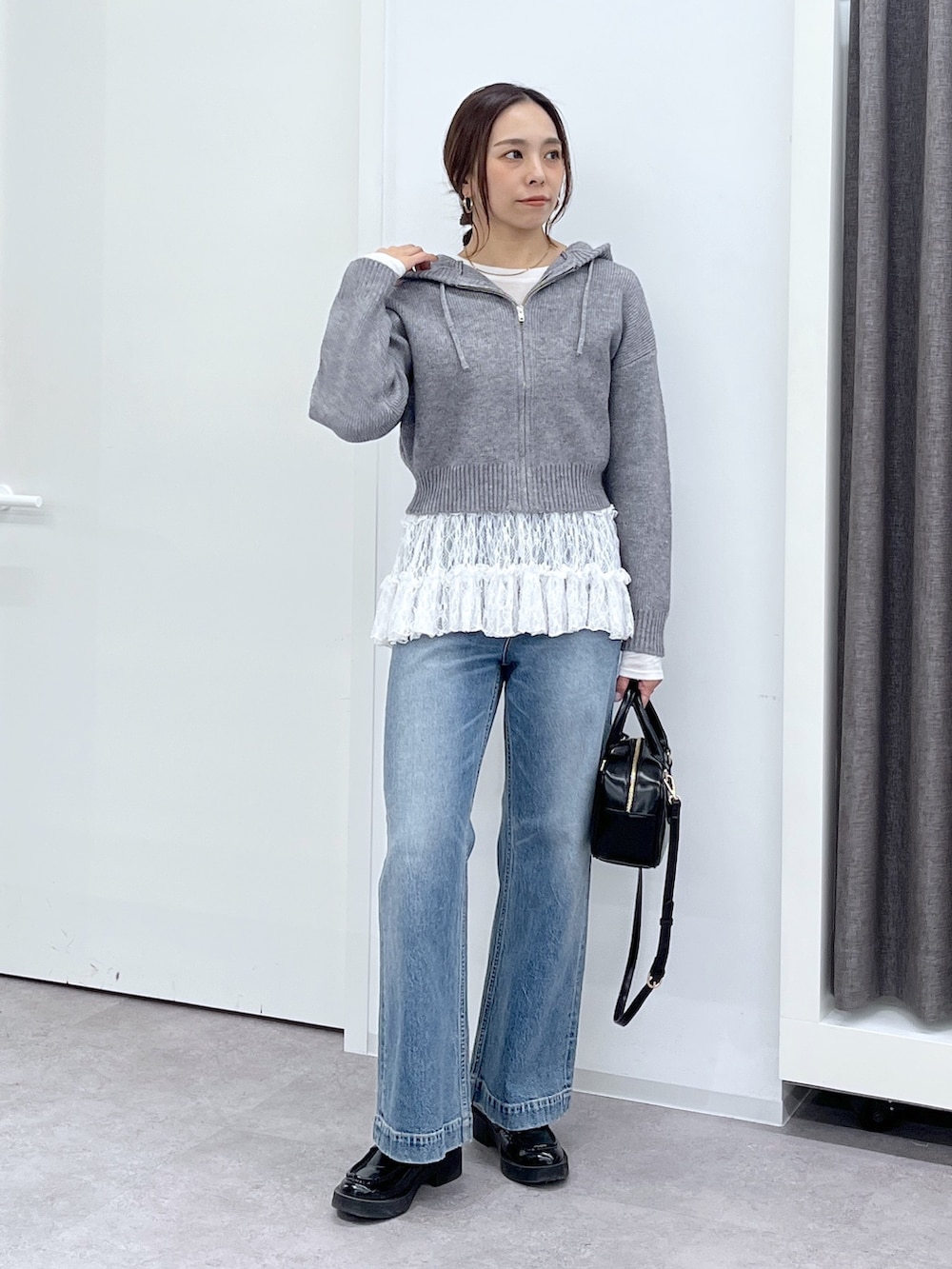 ブラック系のショルダーバッグ、ブルー系のデニムパンツ、ホワイト系のTシャツ/カットソーを着用したレディースの冬コーディネートの3枚目の写真