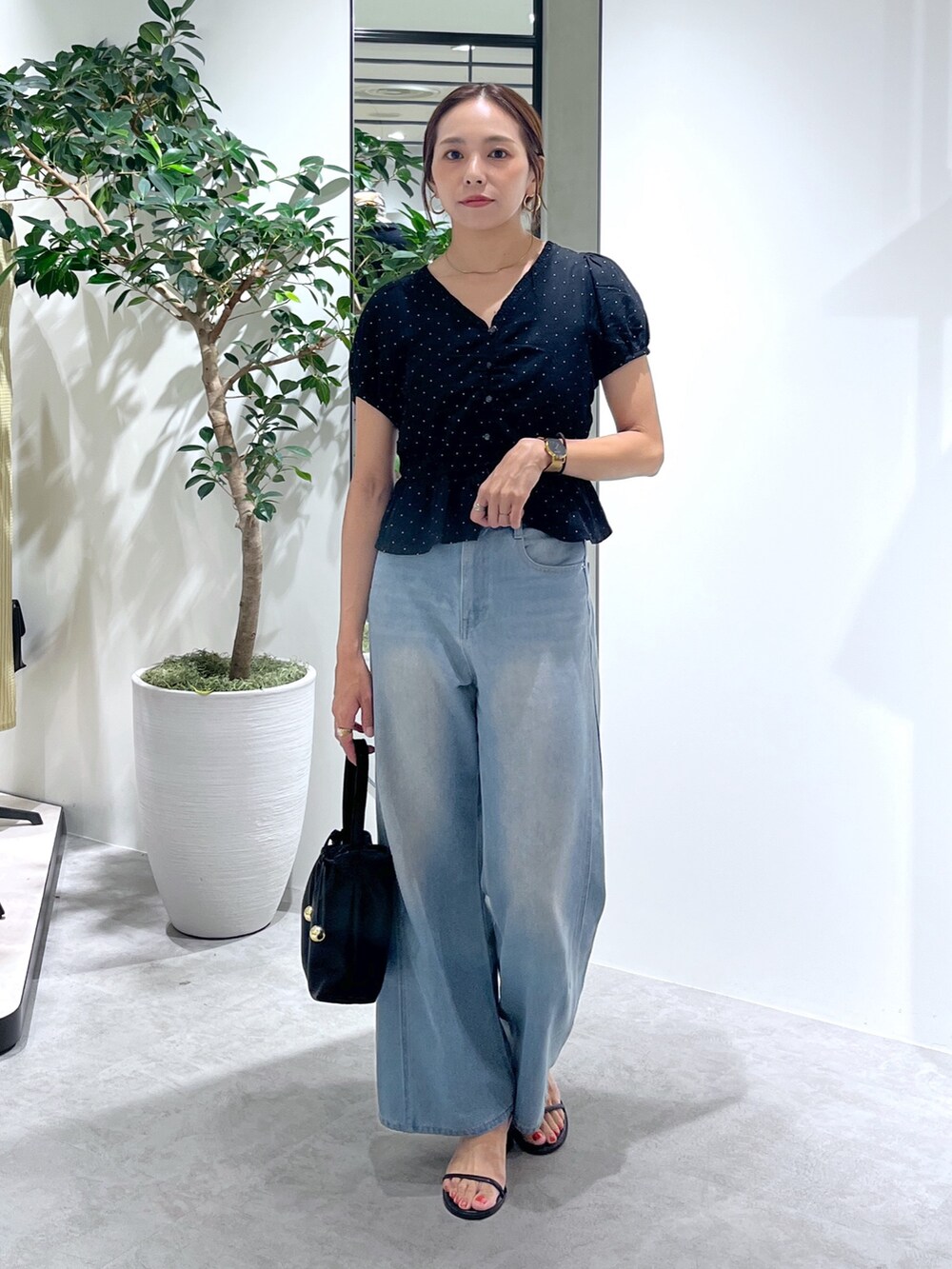 ブラック系のショルダーバッグ、ブルー系のデニムパンツ、ブラック系のシャツ/ブラウスを着用したレディースの夏コーディネートの5枚目の写真