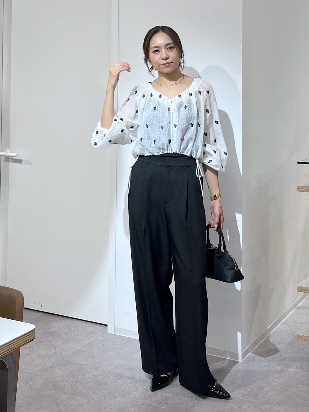 ブラック系のボストンバッグ、ブラック系のスラックス、ブラック系のパンプスを着用したレディースの夏コーディネートの3枚目の写真