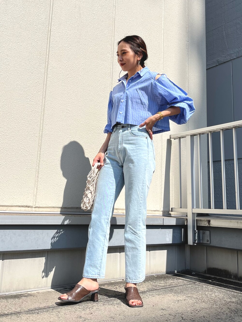 ブルー系のシャツ/ブラウス、ブルー系のデニムパンツを着用したレディースの春コーディネートの2枚目の写真