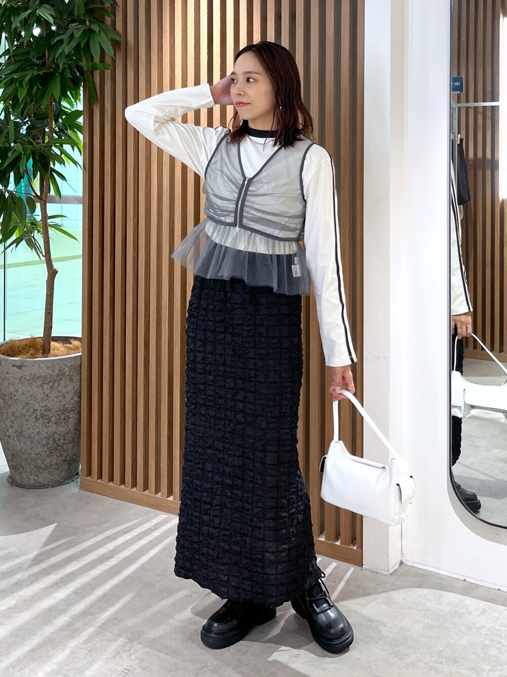 ホワイト系のTシャツ/カットソー、グレー系のシャツ/ブラウス、ブラック系のスカートを着用したレディースの秋コーディネートの9枚目の写真