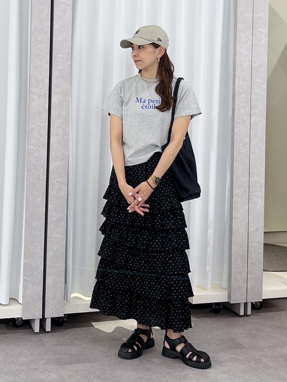 ブラック系のトートバッグ、ブラック系のスカート、グレー系のTシャツ/カットソーを着用したレディースの春コーディネートの7枚目の写真