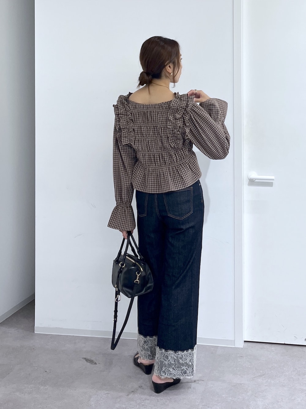 ブルー系のデニムパンツ、ブラック系のハンドバッグ、ブラウン系のシャツ/ブラウスを着用したレディースの秋コーディネートの4枚目の写真