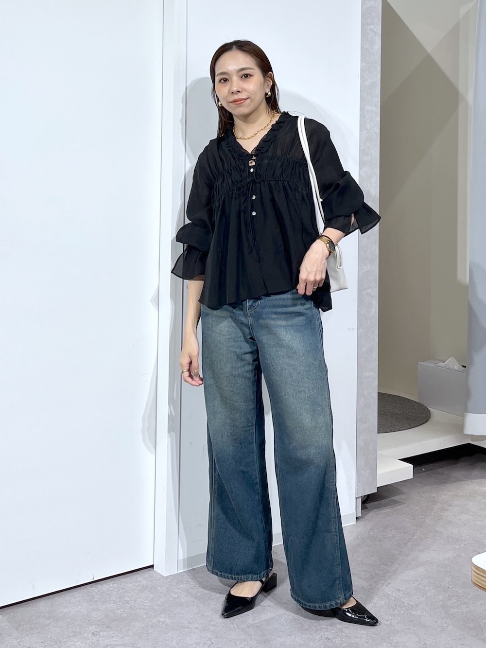 ブラック系のシャツ/ブラウス、ブルー系のデニムパンツを着用したレディースの春コーディネートの2枚目の写真