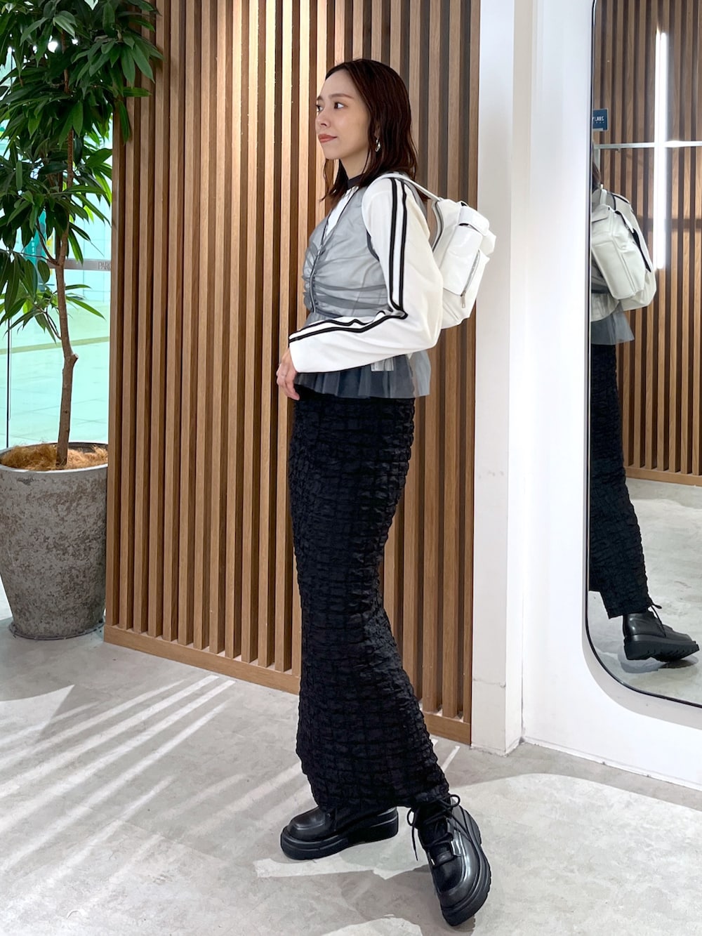 ホワイト系のTシャツ/カットソー、グレー系のシャツ/ブラウス、ブラック系のスカートを着用したレディースの秋コーディネートの7枚目の写真